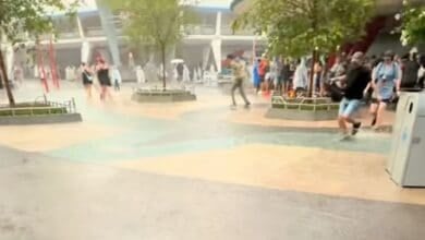 People walking through a flooded Tomorrowland in Magic Kingdom