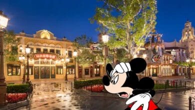 A worried-looking Mickey Mouse in front of stores at Shanghai Disneyland at nighttime