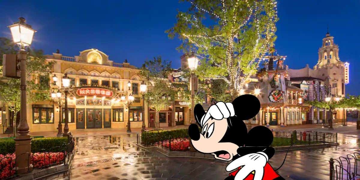 A worried-looking Mickey Mouse in front of stores at Shanghai Disneyland at nighttime