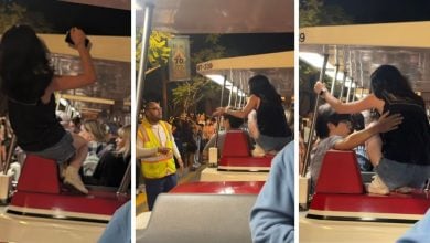 A woman climbs on the Disneyland Tram