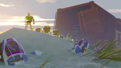 A group of Buzz Lightyear action figures stands on a sandy dune near broken spacecraft pieces, with a large open shipping container in the background as the sun sets.