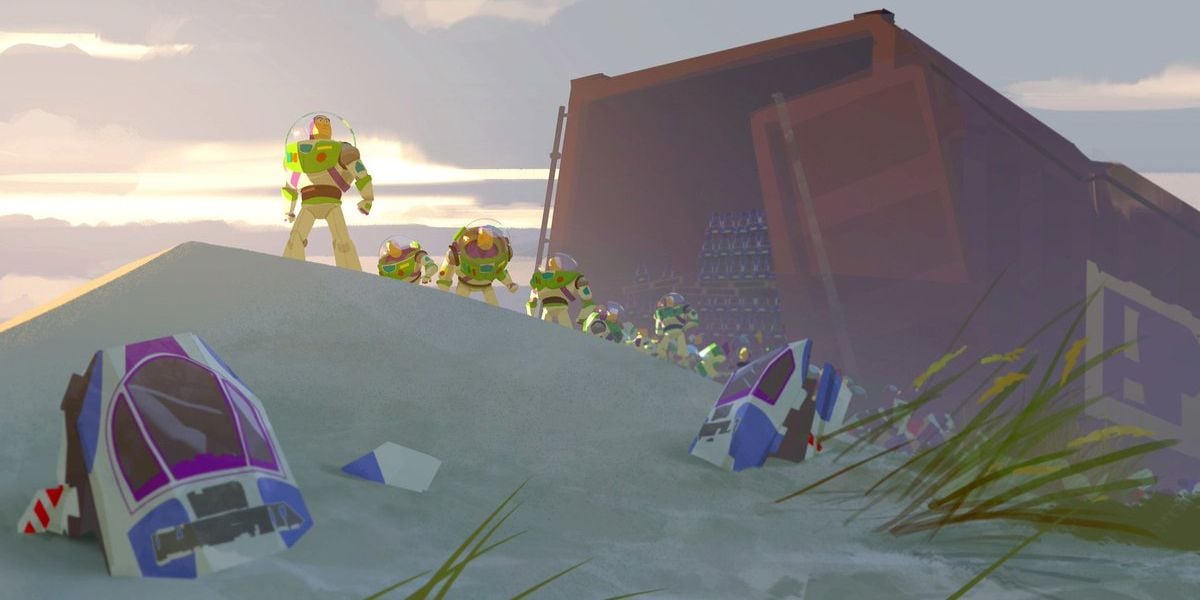 A group of Buzz Lightyear action figures stands on a sandy dune near broken spacecraft pieces, with a large open shipping container in the background as the sun sets.