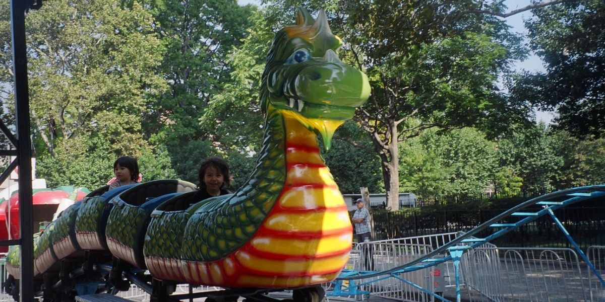 Children ride a dragon kiddie roller coaster, similar to the one involved in a recent viral accident.