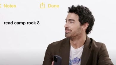 A man with curly dark hair, wearing a brown blazer and holding a phone, looks to the side. On the left, text reads "read camp rock 3" in the style of a Notes app on a white background.