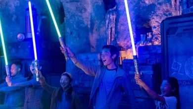 People with lightsabers at Savi's Workshop in Star Wars: Galaxy's Edge.