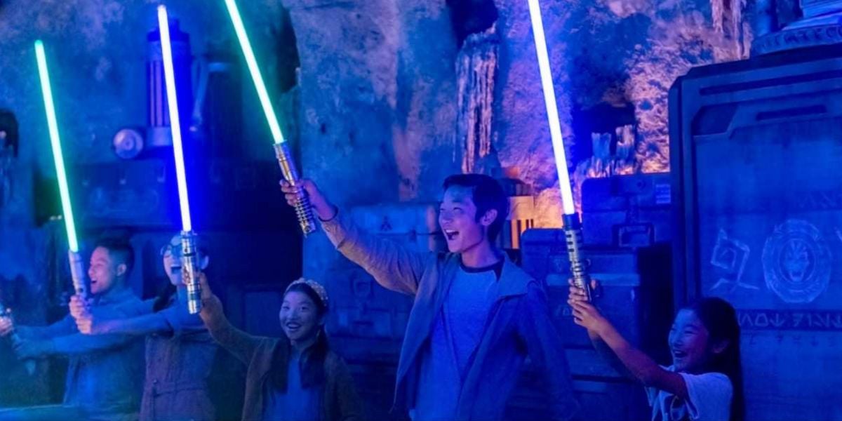 People with lightsabers at Savi's Workshop in Star Wars: Galaxy's Edge.