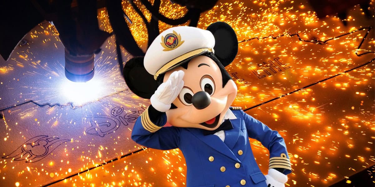 Mickey Mouse in a captain’s uniform salutes in front of a background with bright orange sparks flying from a metal-cutting machine.