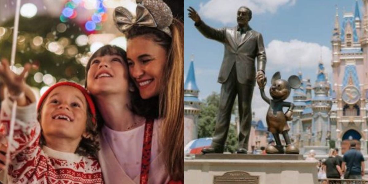 A happy family enjoys Christmas at a theme park, with bright lights in the background. Next to them is a statue of Walt Disney holding hands with Mickey Mouse in front of a castle.