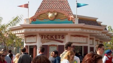 Guests buying Disneyland Resort tickets at a booth at the park.