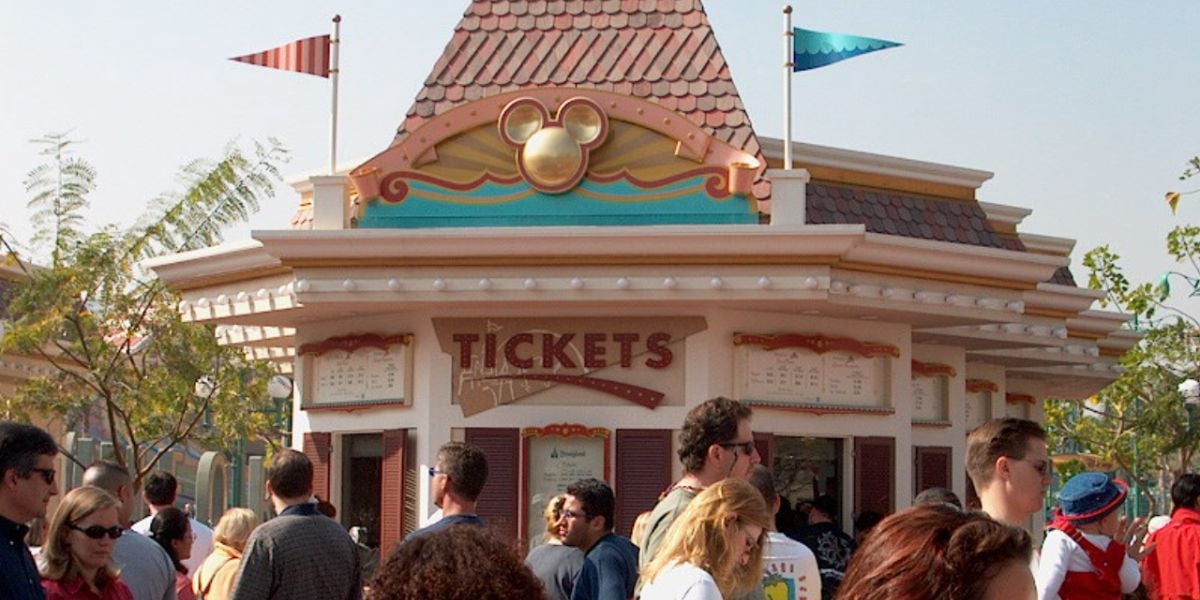 Guests buying Disneyland Resort tickets at a booth at the park.