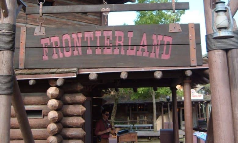A wooden sign reading "FRONTIERLAND" at the Magic Kingdom.