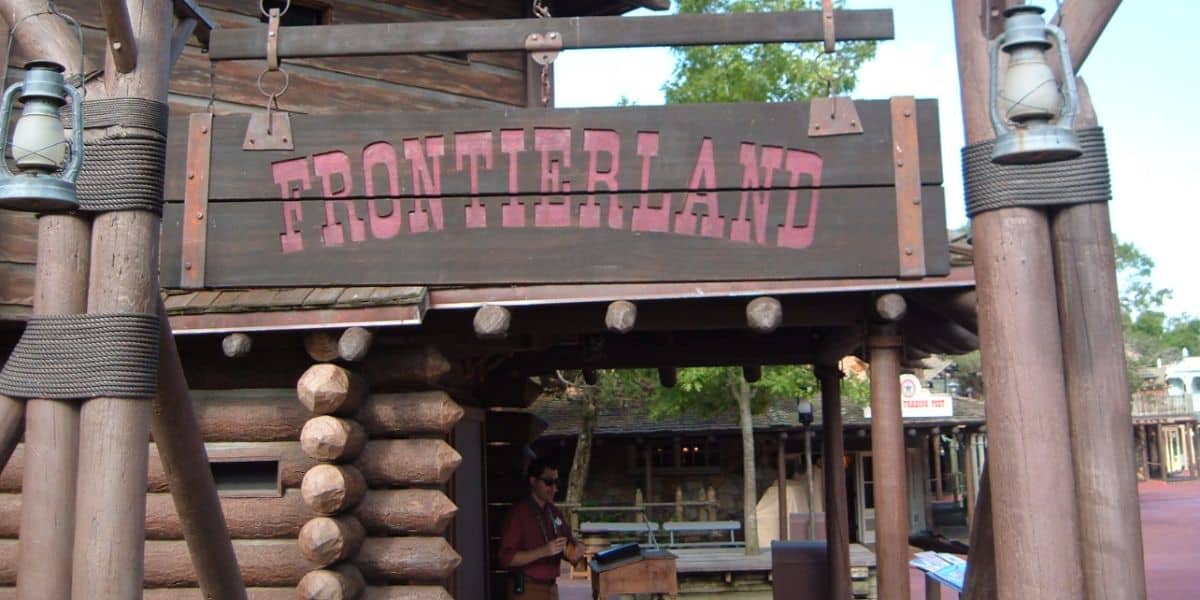 A wooden sign reading "FRONTIERLAND" at the Magic Kingdom.