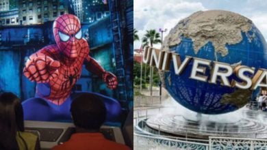 Two people view a large screen showing Spider-Man in action on the left; on the right is the iconic Universal Studios globe with gold lettering and palm trees in the background.