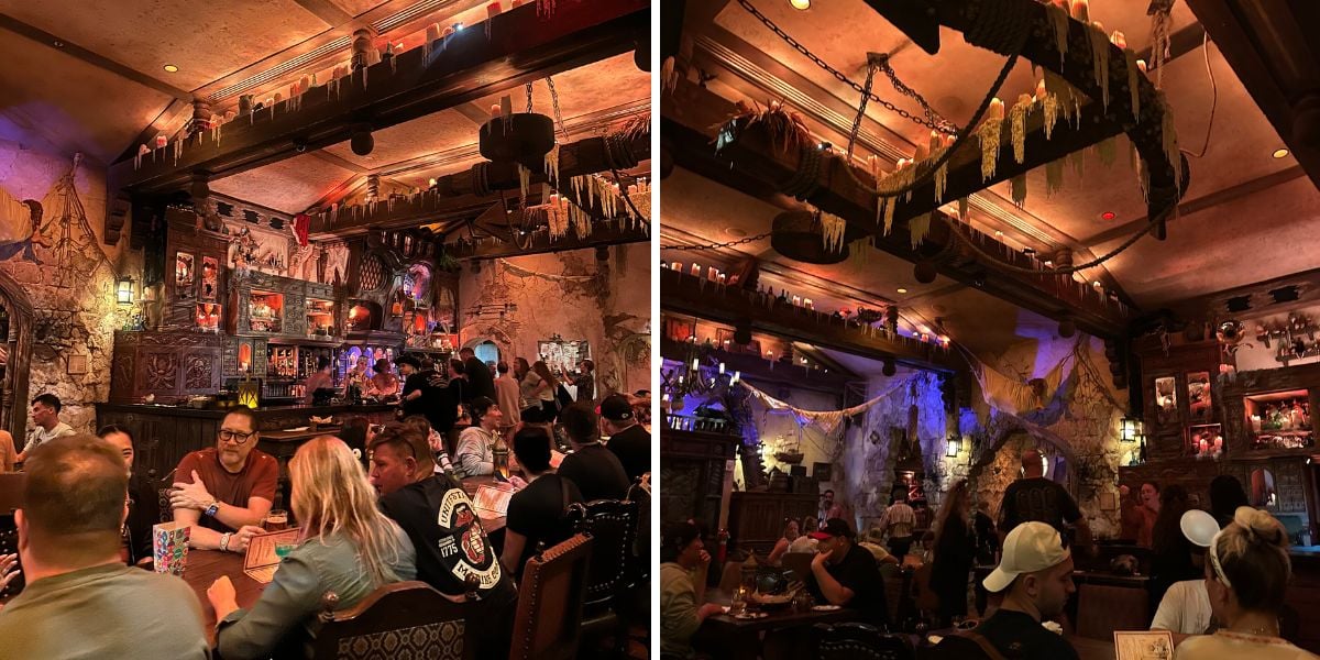 A dimly lit, medieval-themed restaurant filled with people dining at wooden tables. The decor features candles, cobwebs, stone walls, and shelves displaying eerie objects and glowing lights.