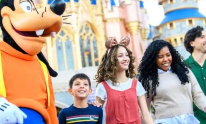 Disney World guests in front of Cinderella Castle in Magic Kingdom park with Goofy