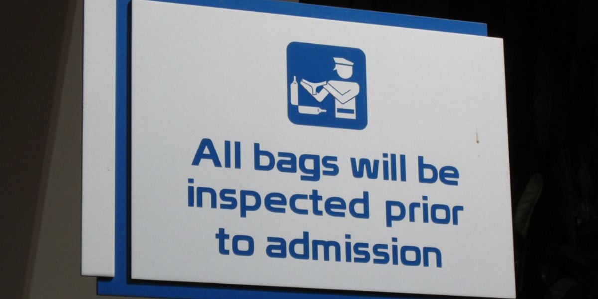 A Disney security sign at EPCOT reads "All bags will be inspected prior to admission."