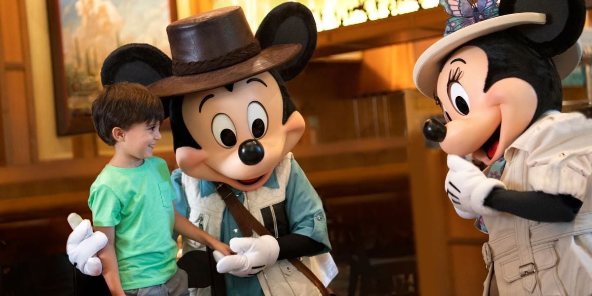 A young boy meets Mickey Mouse and Minnie Mouse at Storyteller's Cafe