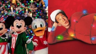 Minnie Mouse, Mickey Mouse, and Donald Duck in festive outfits stand by a Christmas tree, next to a man in a red suit and Santa hat lying on his side, wrapped in colorful Christmas lights.