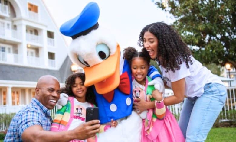 A family of four takes selfie with Donald Duck