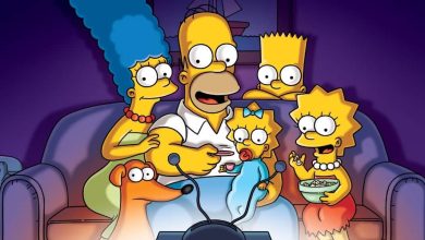 The Simpsons—Marge, Homer, Bart, Lisa, Maggie, and their dog—sit together on a couch, smiling as they watch TV in a dimly lit living room. The Simpsons' TV’s antenna is visible in the foreground.