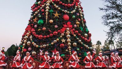 performers dance around a giant Christmas tree at Universal Orlando Resort during the holiday season