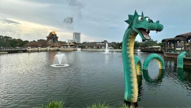 The iconic green LEGO sea serpent emerges from the Disney Springs lake, just steps from top shops and a volcano-themed eatery.