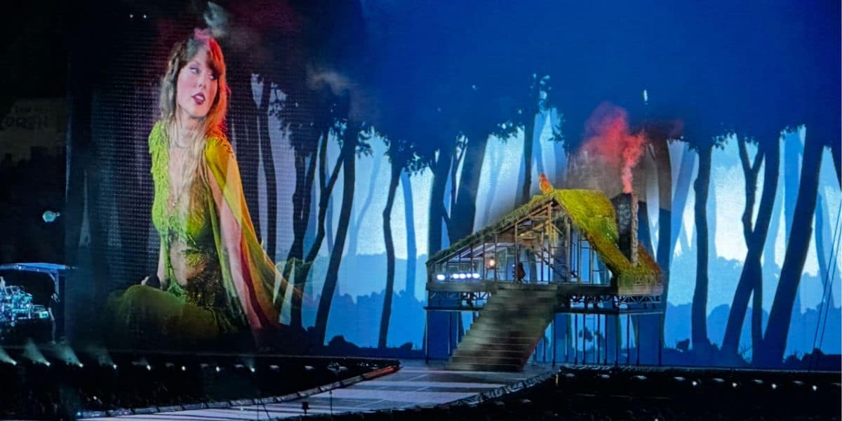 On the Enchanted Forest stage, a vibrant singer in green dazzles the crowd against a magical woodland digital backdrop.