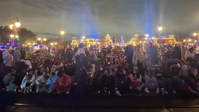 Guests gather on Main Street, eagerly seated under the night sky, awaiting the dazzling parade at Magic Kingdom.