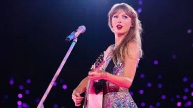 Taylor Swift in a bejeweled bodysuit with a guitar onstage during the "Lovers" set of The Eras Tour