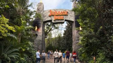 guests pass Jurassic Park gate entrance in Universal Orlando's Islands of Adventure park