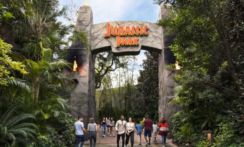 guests pass Jurassic Park gate entrance in Universal Orlando's Islands of Adventure park