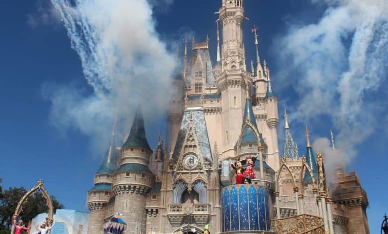 Cinderella Castle lit up by fireworks during the day.