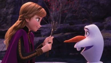 Anna holds a stick in front of Olaf