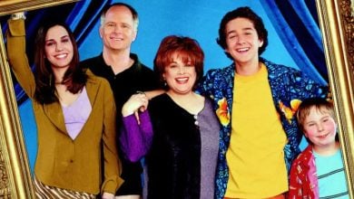 Christy Carlson Romano and friends pose with big smiles in a tilted frame, set against blue curtains for that Disney Channel magic.