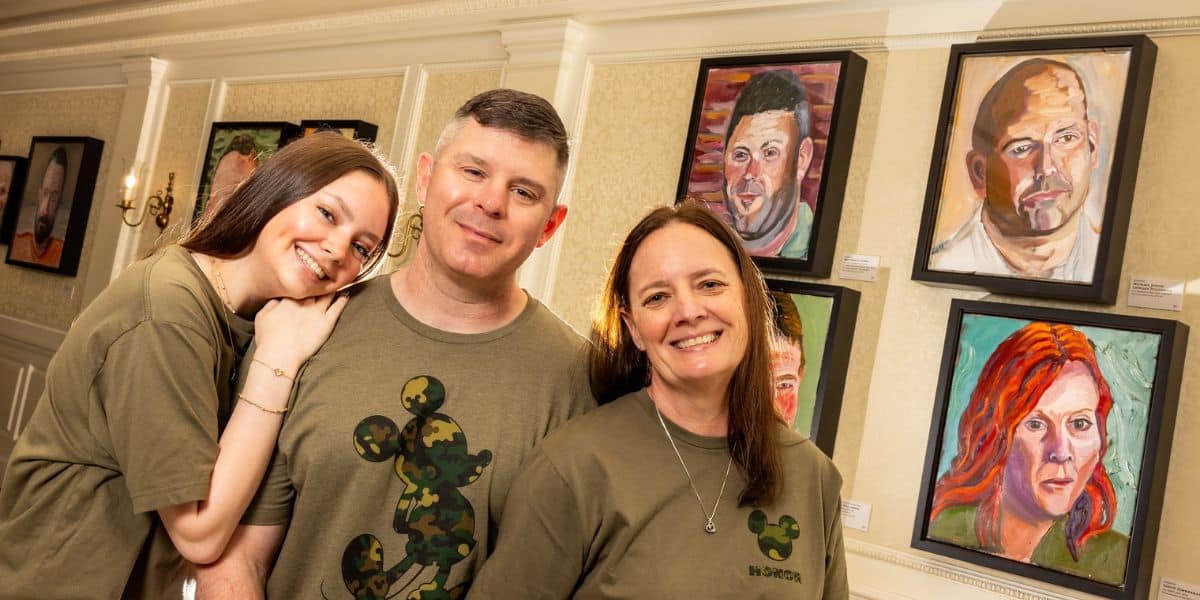 A family in the Portraits of Courage exhibit at EPCOT