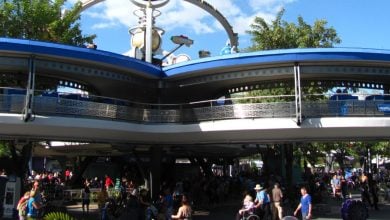 Guests stroll beneath the iconic PeopleMover track in Tomorrowland at Magic Kingdom