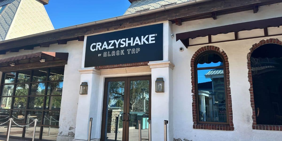Entrance to Crazyshake by Black Tap at Universal CityWalk, with the colorful sign above sleek glass double doors.