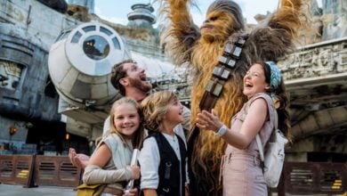 disney family poses with chewbacca at galaxy's edge in disney's hollywood studios park