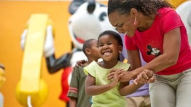 mother and her child in front of mickey statue at pop century resort in disney world
