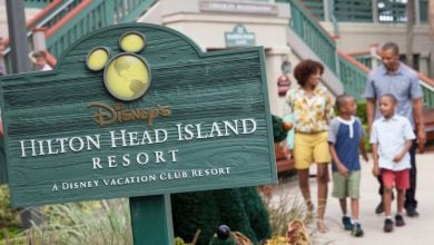 Guests stroll by the iconic Disney’s Hilton Head Island Resort sign at the Vacation Club entrance, ready for a magical getaway.