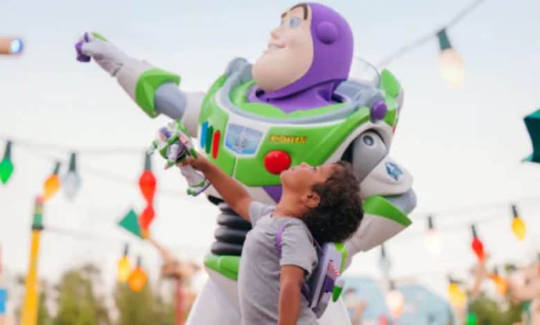 a young guest poses with Buzz Lightyear in Toy Story Land in Disney's Hollywood Studios park.