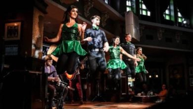 Irish dancers in green costumes light up the stage at Disney Springs’ St. Patrick’s Day Festival, with live music energizing the crowd.