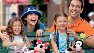 a Disney World family inside the parks with Minnie and Goofy stuffed animals. Disney World curfew rules 2026