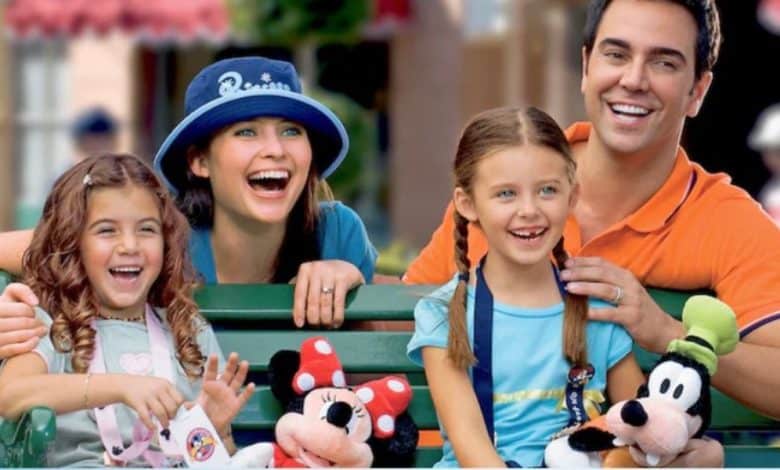 a Disney World family inside the parks with Minnie and Goofy stuffed animals. Disney World attendance decline.