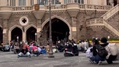 Guests shelter from an earthquake near Cinderella Castle at Tokyo Disneyland.