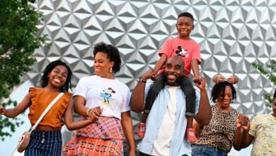 family in front of spaceship earth in disney world's epcot park
