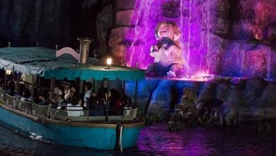 Jungle Cruise boats float past a lifelike elephant