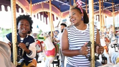 a mom and her son ride the prince charming carousel in disney world's magic kingdom park