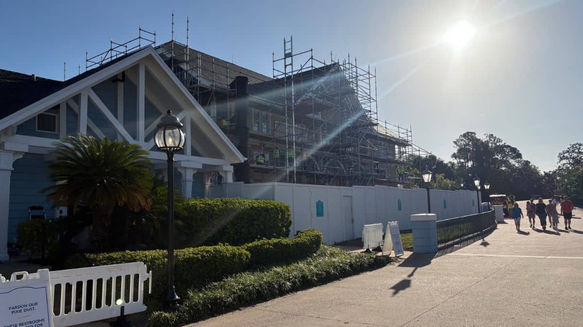 Disney Beach Club Resort under renovation with scaffolding, fencing, and guests strolling by on a bright day during 2027 updates.