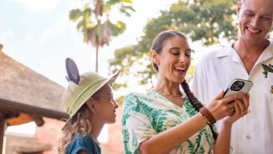 family uses phone at Disney World